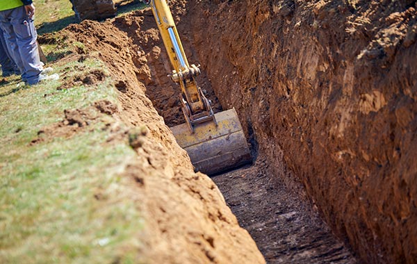 <img src="excavation.jpg" alt="excavator digging trench in grass field">