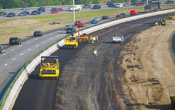 <img src="encroachment.jpg" alt="paving of right side of freeway with cement barriers">