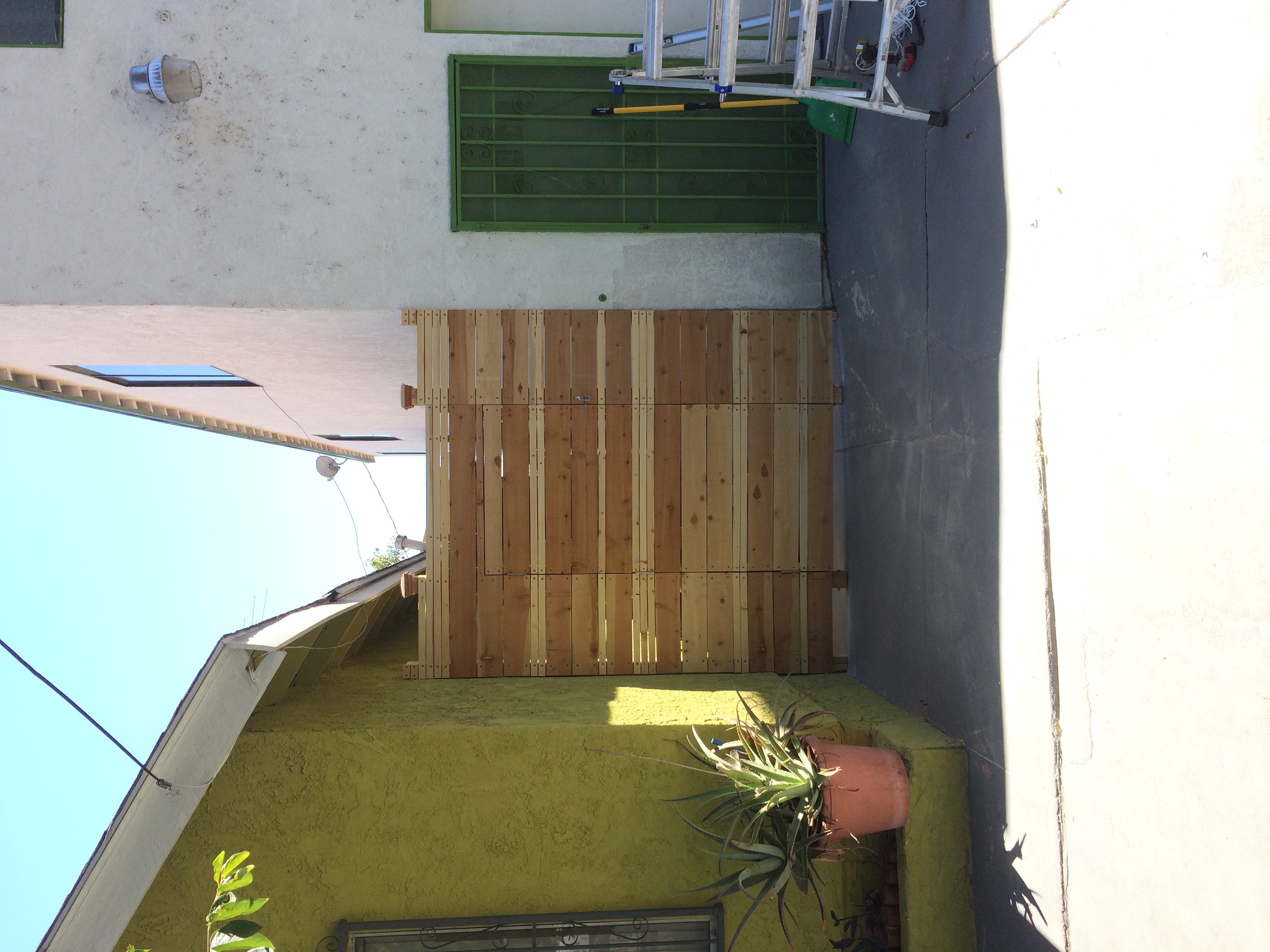 <img src="Mike2.jpg" alt="wooden gate between two buildings installed by Mike Urquizo">