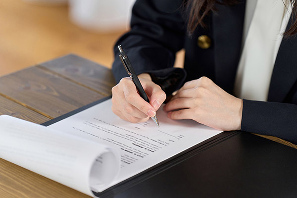 Professional completing Nevada commercial surety bond agreement on a clipboard.
