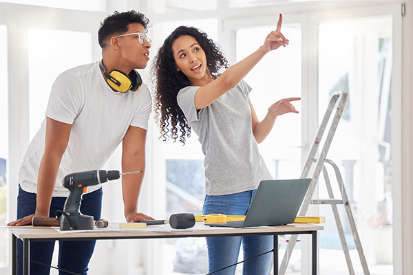 Young woman points out something to a man during home renovations.